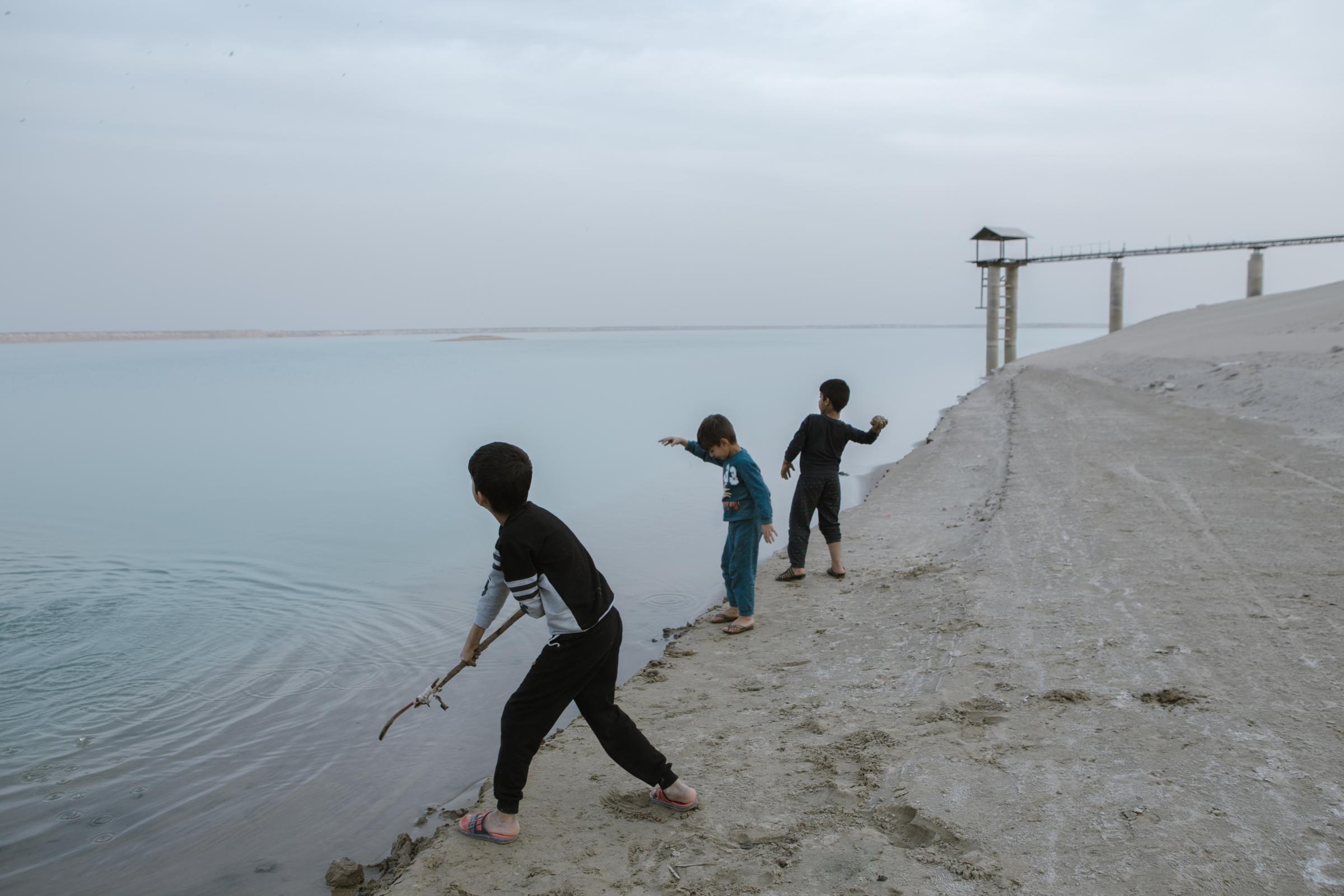 IN THE DESERT OF WETLANDS -   Children are playing around the Chah Nimeh reservoirs....