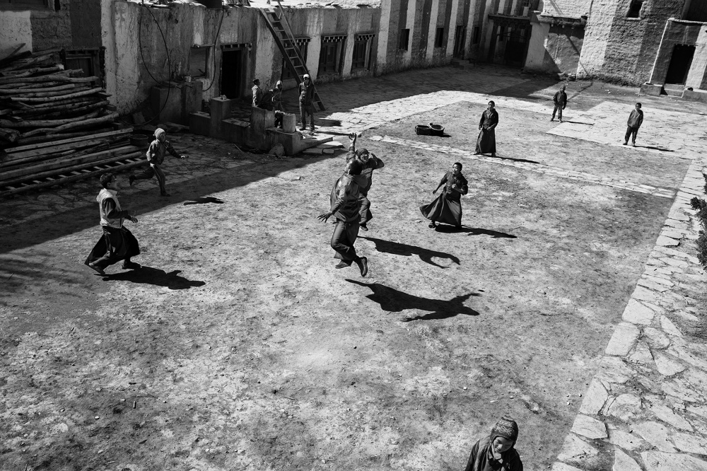 Young monks play baseball in th...ligiuos architecture is intact.