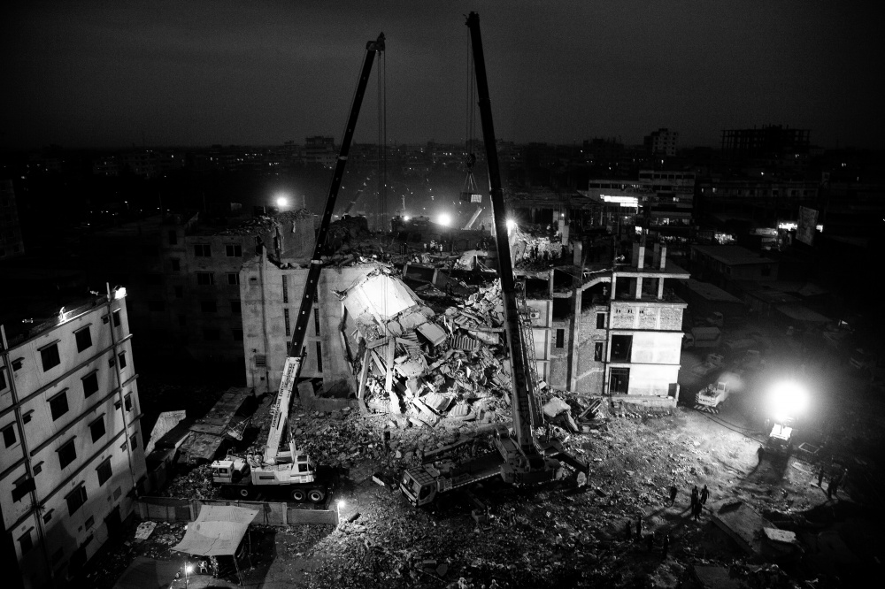 Rescue workers attempt to rescue garment workers from the rubble of the collapsed Rana Plaza building at night time, Savar, near Dhaka, Bangladesh.