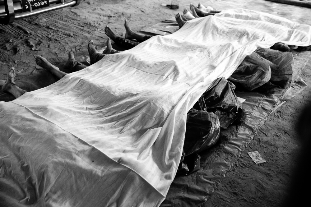 Under the rubble - Dead bodies have been kept wrapped in cloths at Anam...