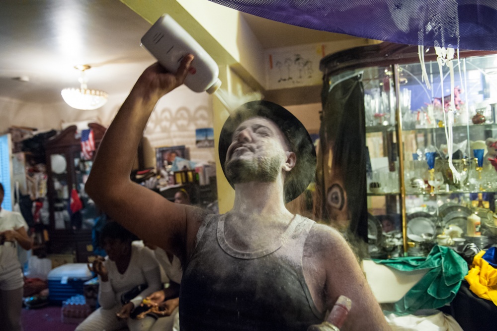 Vodou Brooklyn: Gede -  A Vodou priest pours talcum powder on his face while...