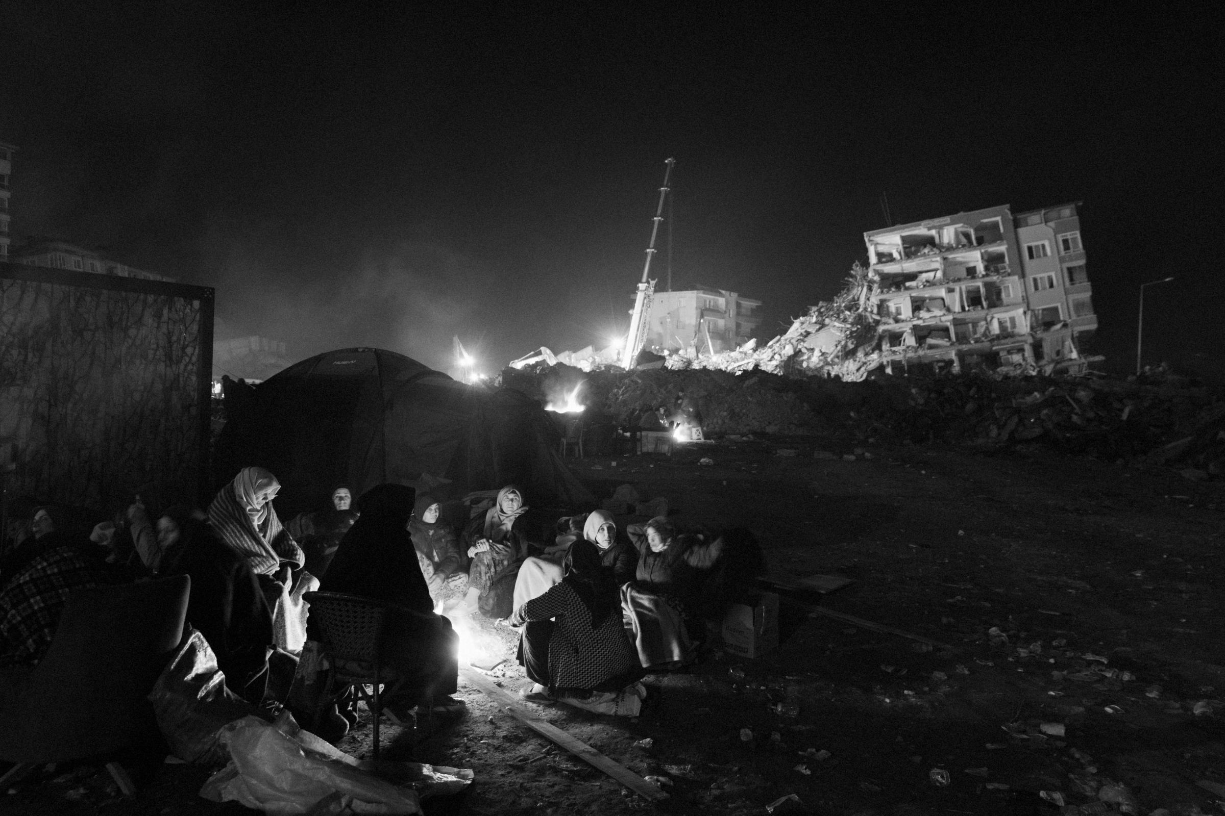 Earthquake in Turkey (2023) - Women are sitting near the fire, fifty meters away from...