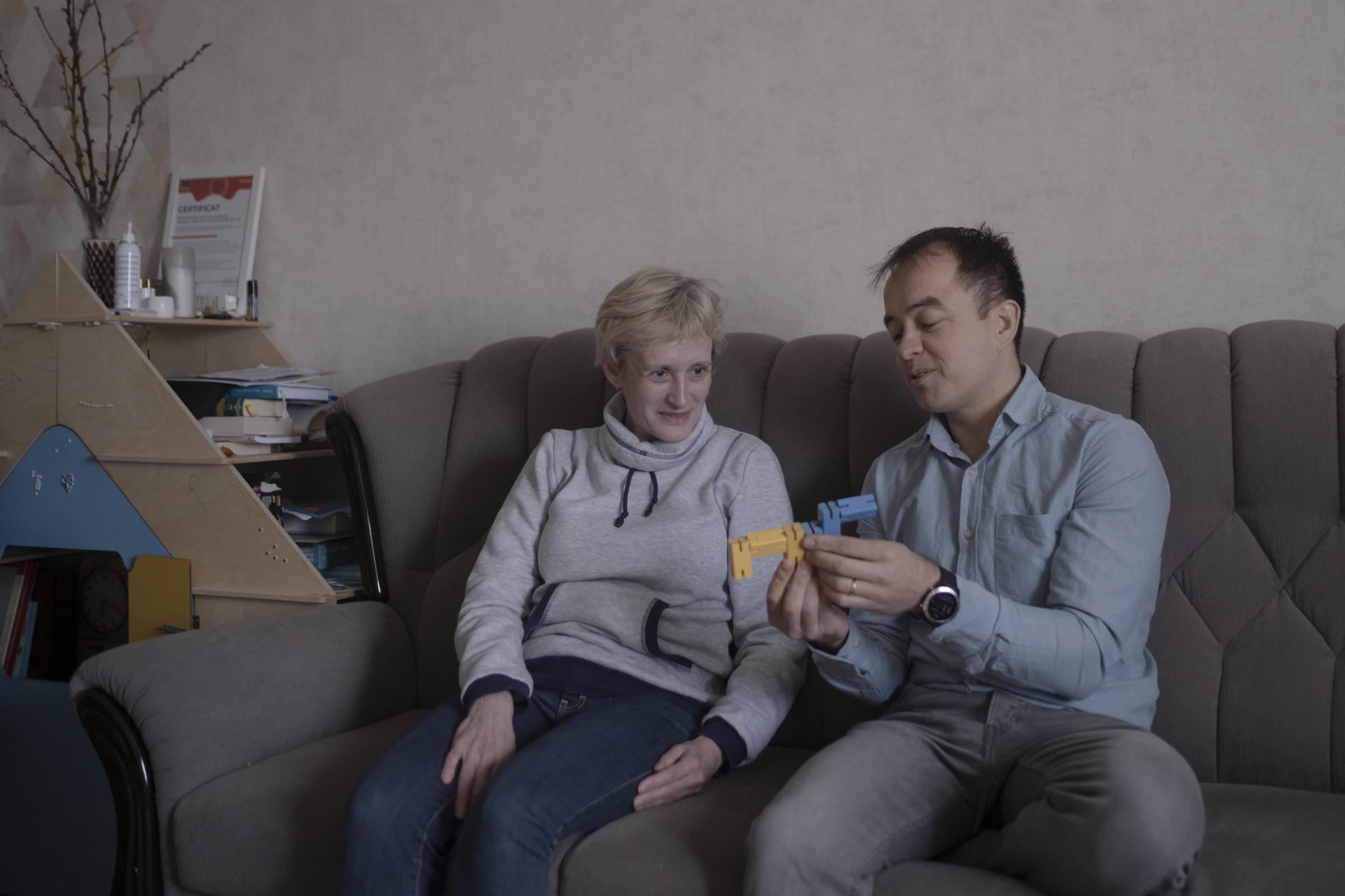 Moldovans who sheltered Ukrainian refugees at home - Igor is showing Edita a wooden toy painted in yellow and...