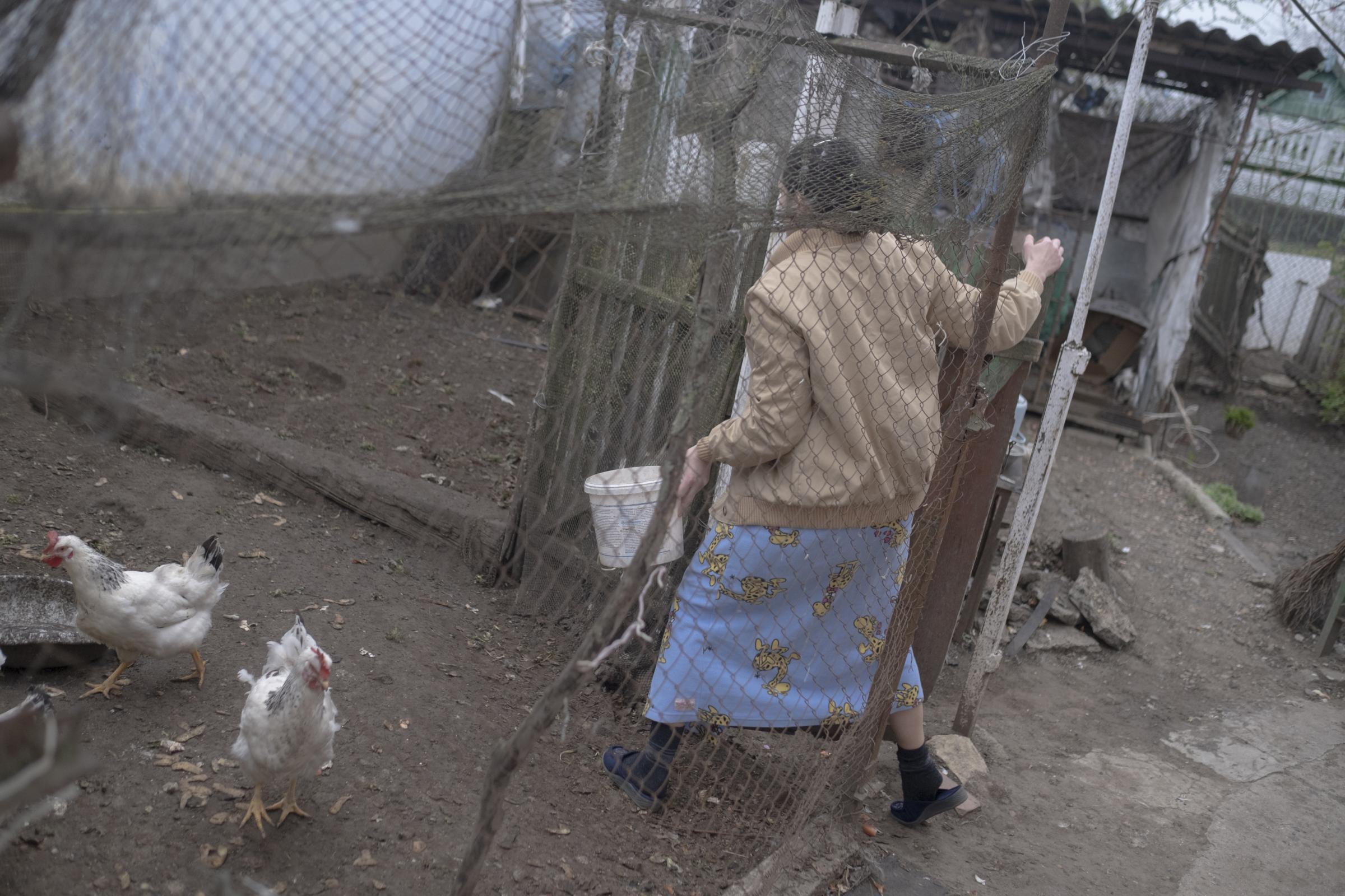 Moldovans who sheltered Ukrainian refugees at home - Lyuda is going to feed chicken.