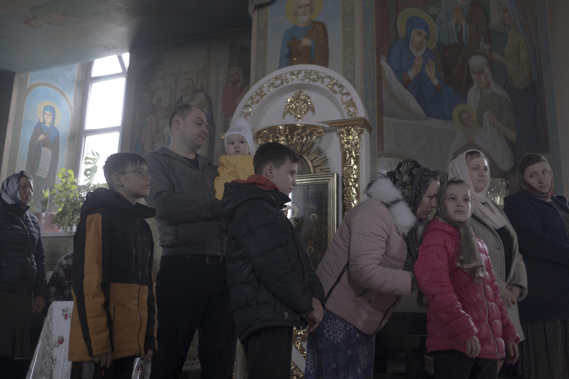Moldovans who sheltered Ukrainian refugees at home - Lena, Georgiy and children are visiting local church.