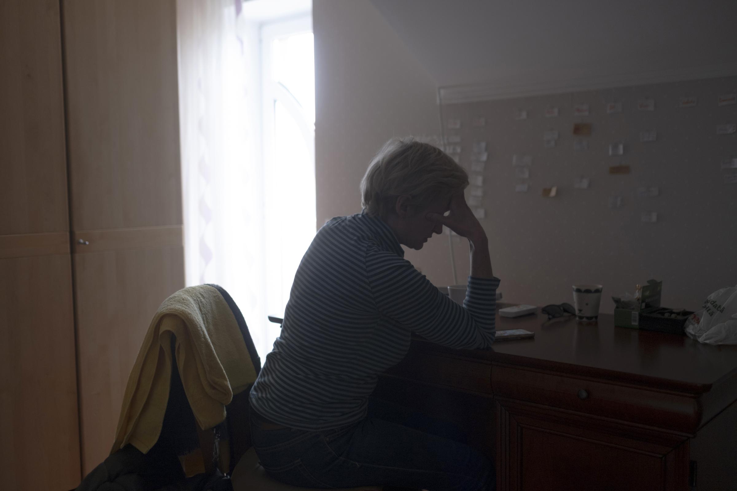 Moldovans who sheltered Ukrainian refugees at home - Edita is reading news on her phone.