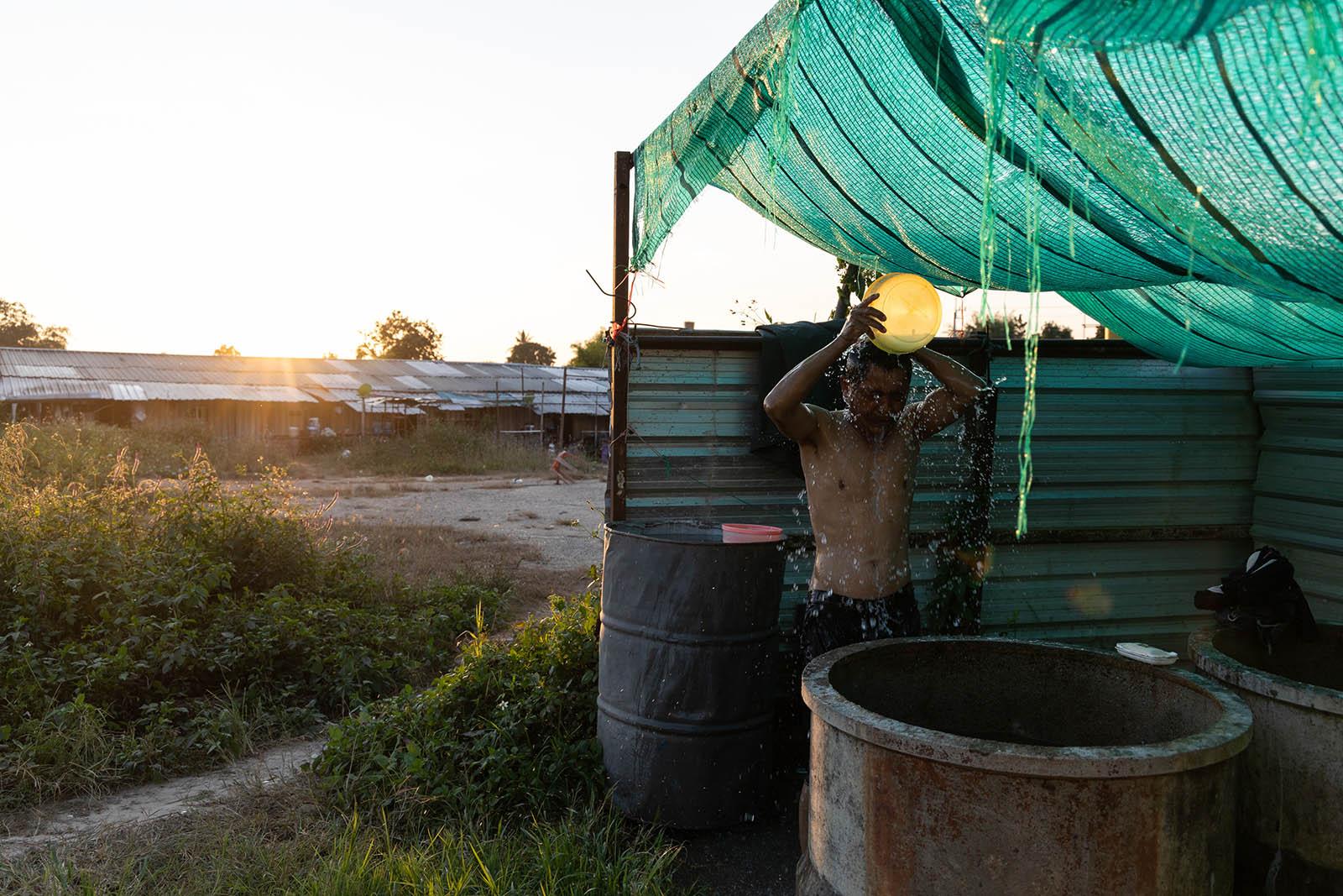 LIFE ON THE OTHER SIDE - Chiang Rai - A migrant worker from Myanmar takes a shower...