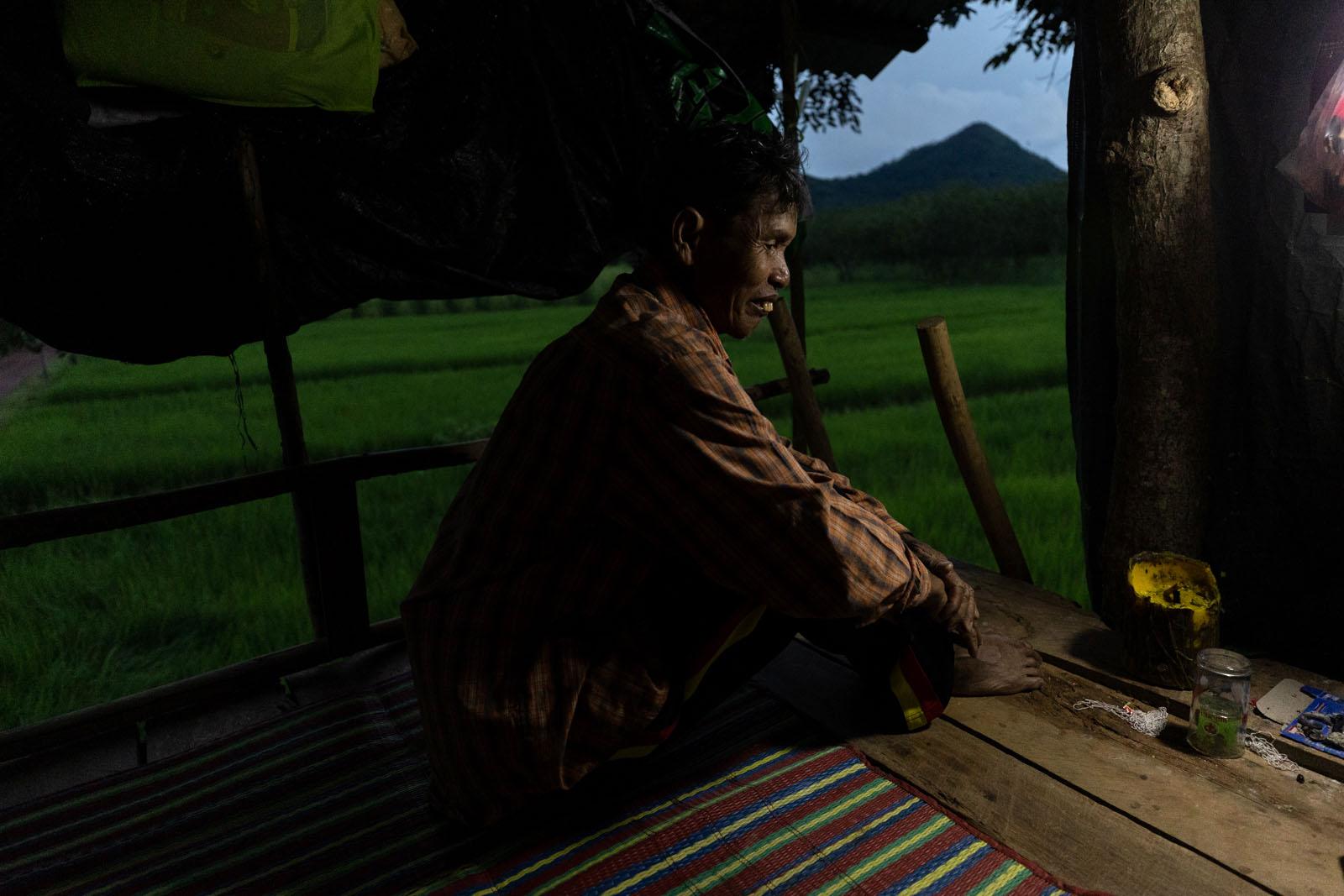 A FRAGILE COEXISTENCE - Yai Neuiklang sits inside his tree house that he built a...