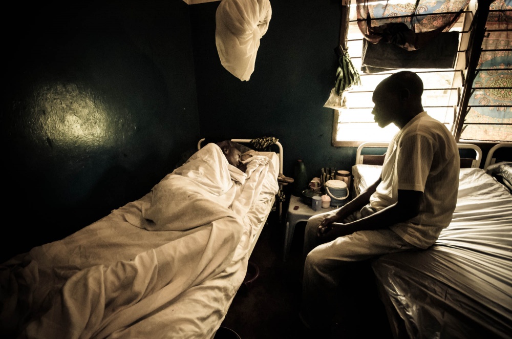  A son sits by his father's bed in Mbuji Mayi, DRC. 