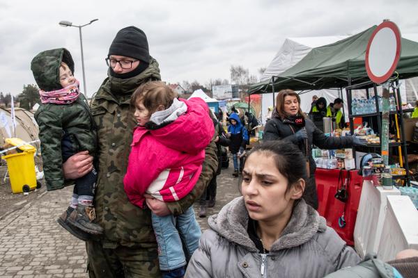 Przemsyl - Milan - From Milan to refugee centers in Poland on the border with Ukraine - A Polish border guard helps a Ukrainian refugee. Behind a CNN correspondent Una guarda di...