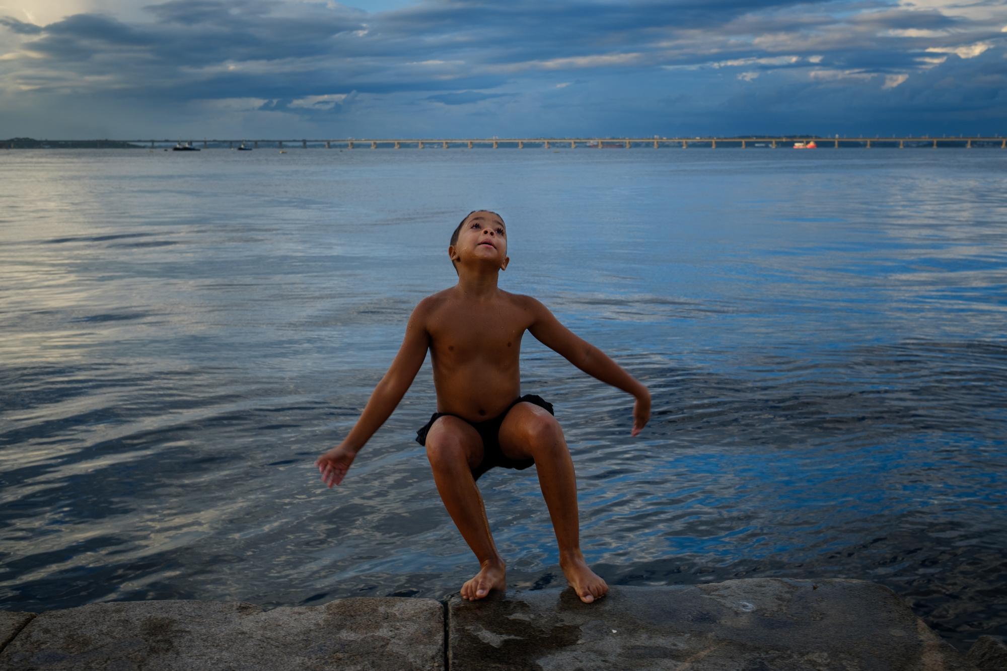 Baía Viva - Rutel, 10, attempts a back flip into the Guanabara Bay in...