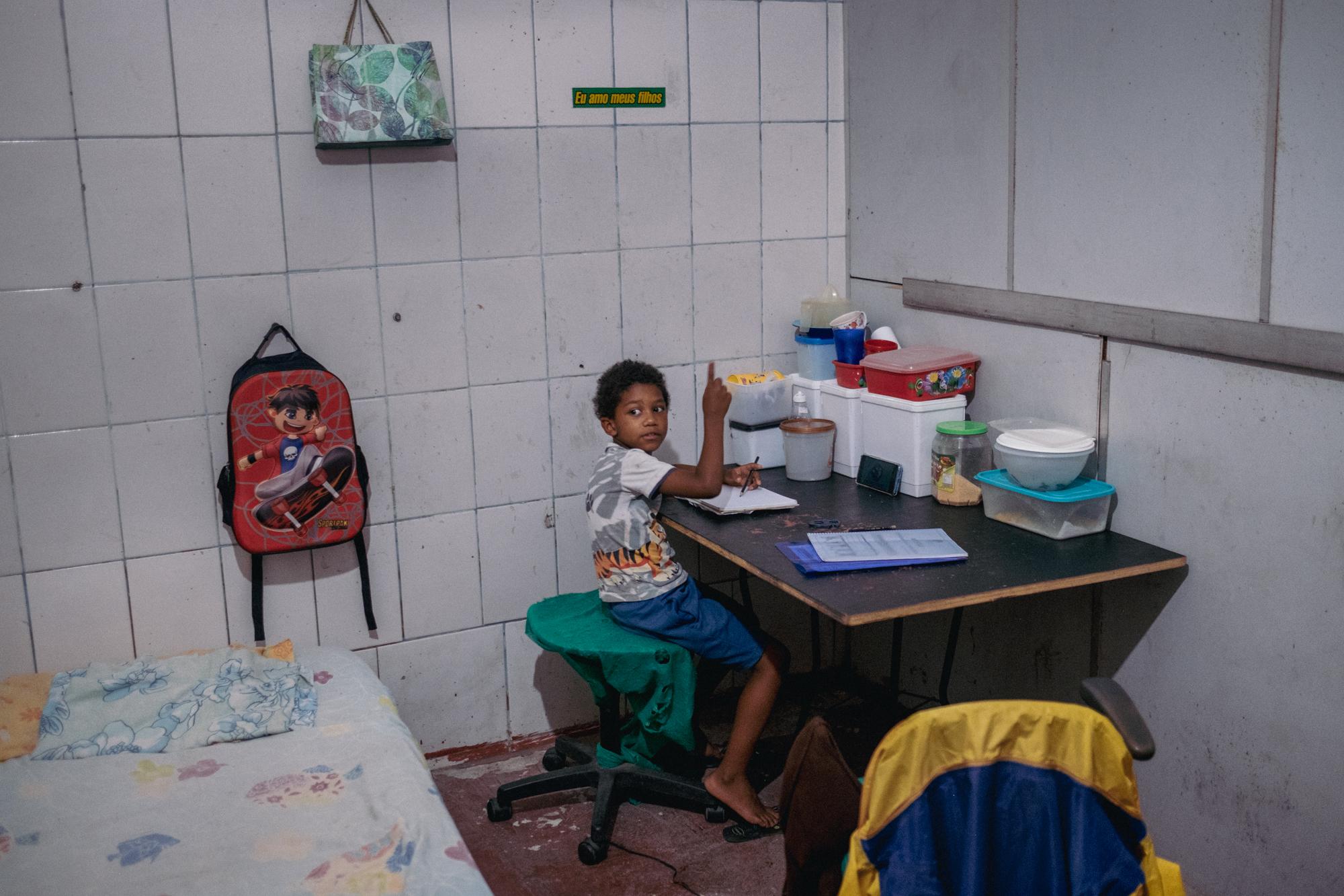 Alexandro, 8, studies on his mother&#39;s cellphone in their home in the Mariana Crioula...