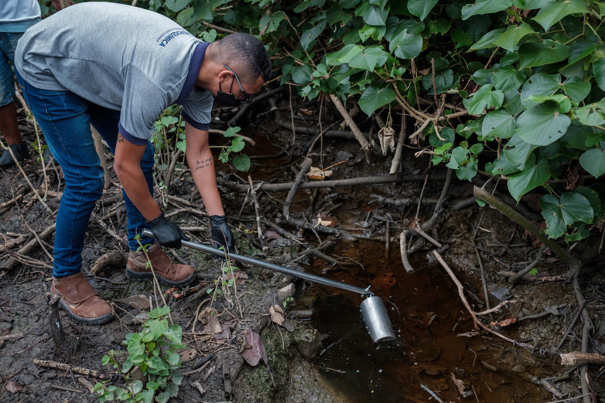 A bio-technician takes a sample of polluted water thought to be leeched from a nearby clandestine...
