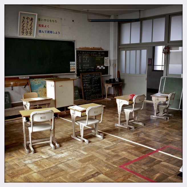 Oda - Empty school desks remain in a classroom at Oda...