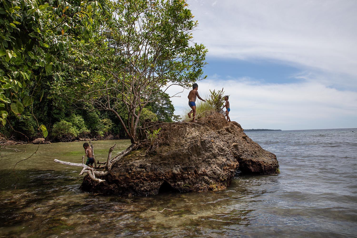 Chuito brothers plays on a natural rock at Solarte Island. Bocas del Toro. Panama. Solarte Island is one of the seven Island of the Bocas del Toro...