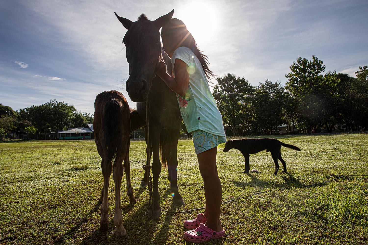Ng&auml;be girl playing with her pony. Pir&oacute;, Panam&aacute;. These indigenous communities have a direct bounding with nature and...