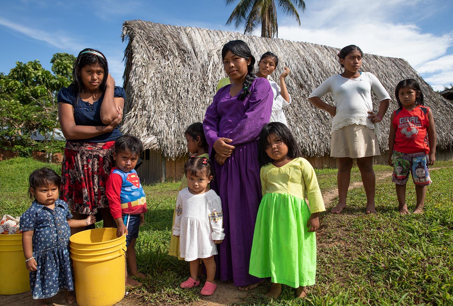 Beyond blue water - Ngäbe women with her children and water tanks for...