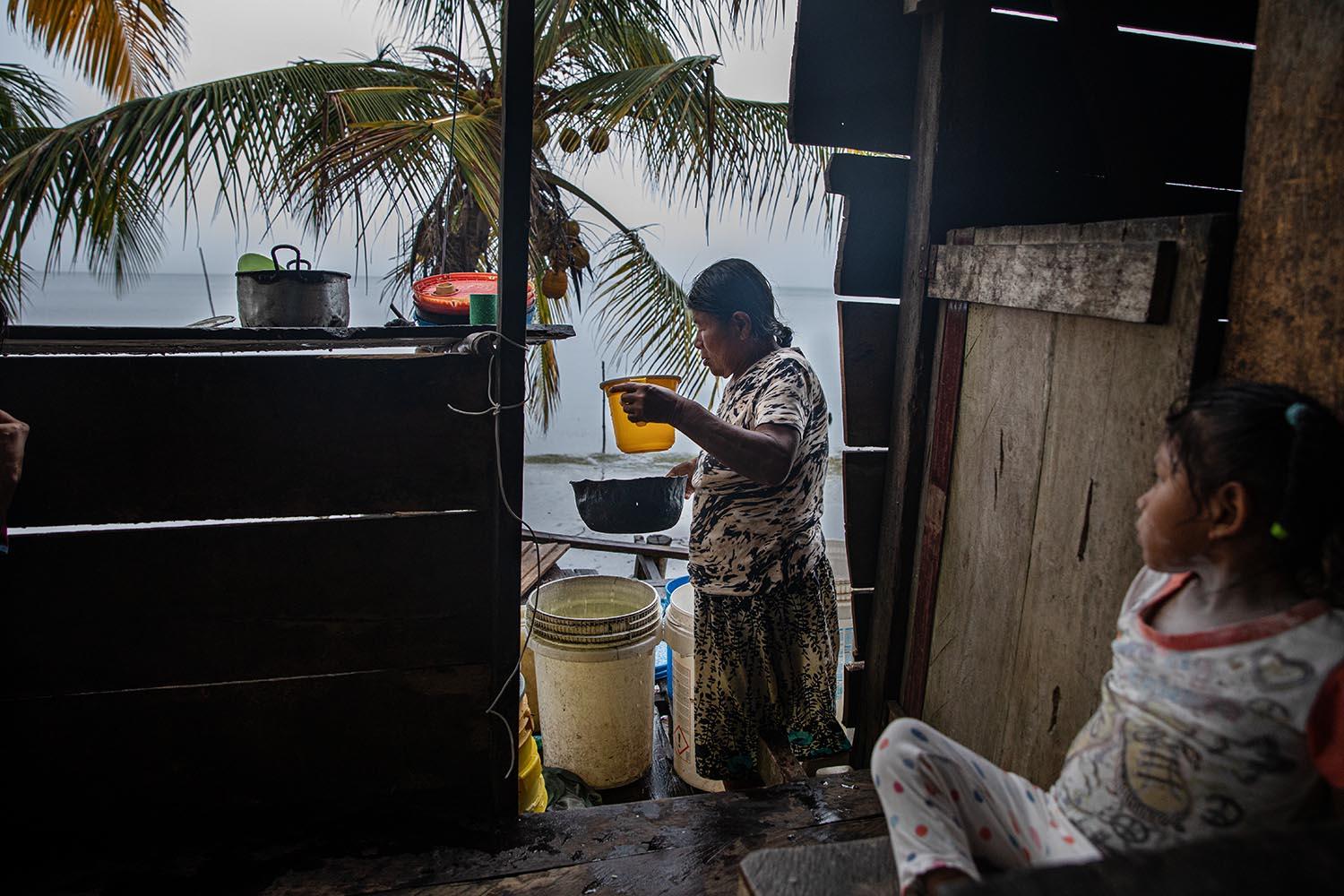 Beyond blue water - A Ngäbe indigenous woman taking some drinkable water...