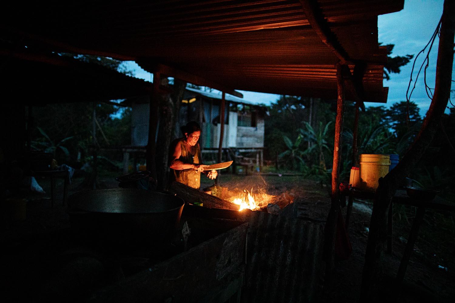 Beyond blue water - Dionisia Hooker cuts coconut with a machete early in the...