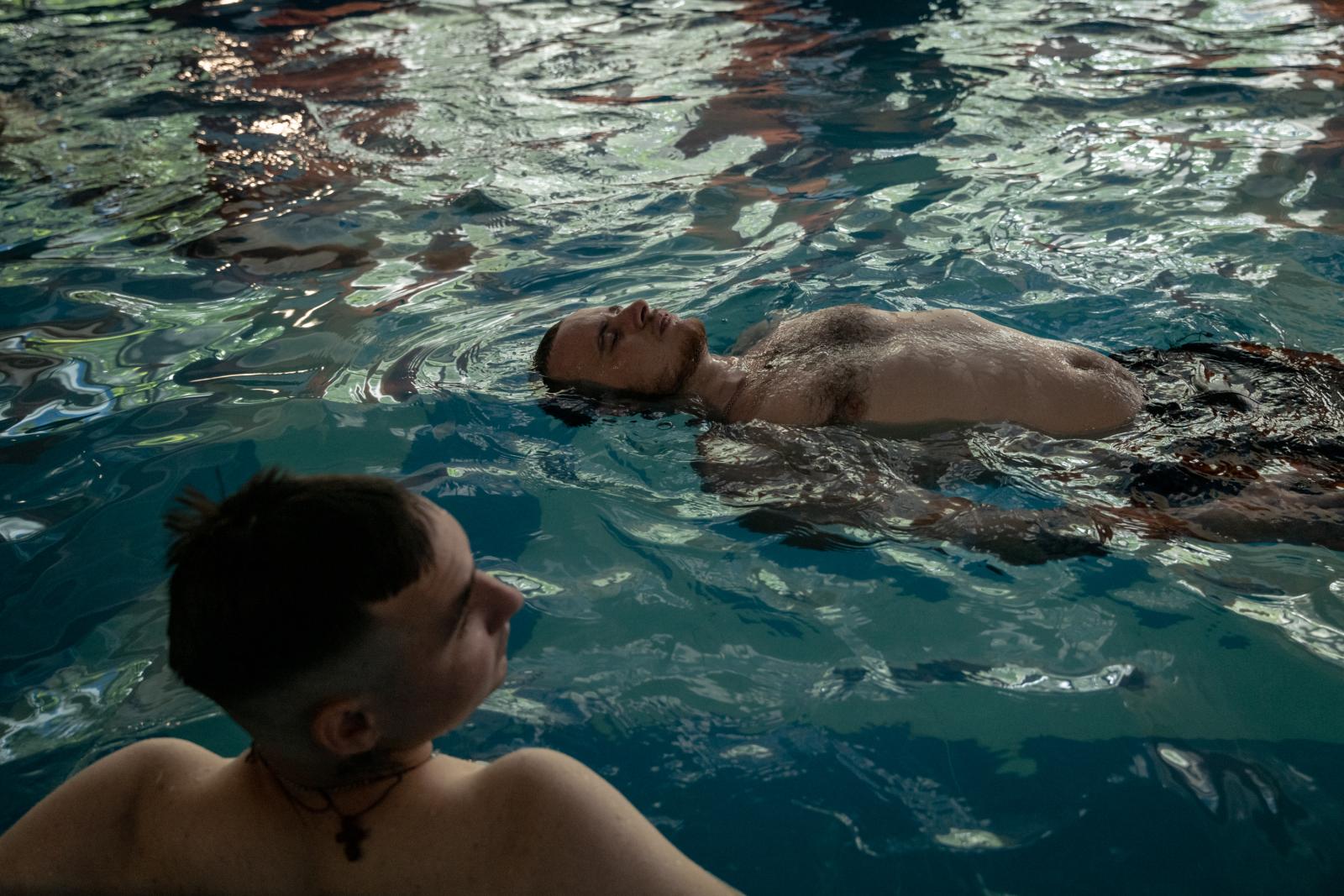 Ukrainian soldiers are seen in ... a session for aquatic therapy.