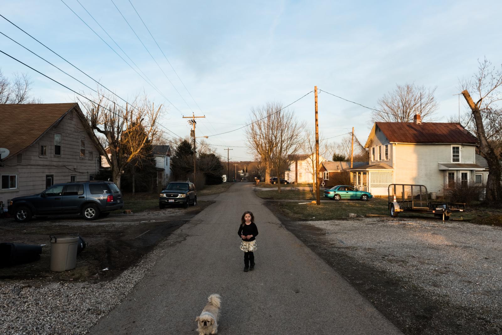 Chloe Harris and her dog walk down their street in Coolville. 