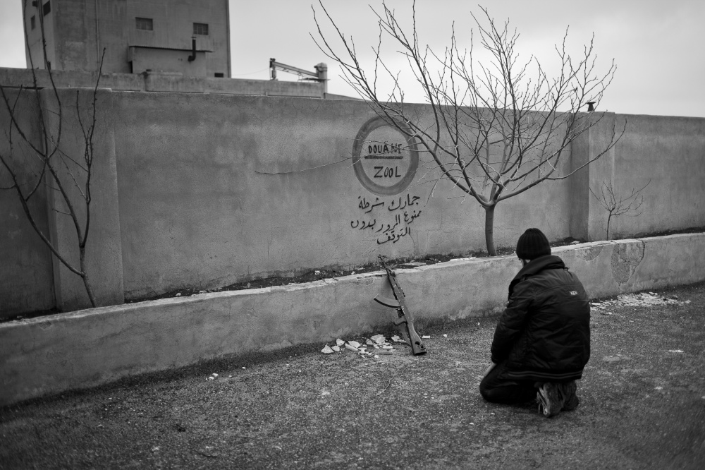 Rebel fighter praying near Maar.... February 2013, Idlib province