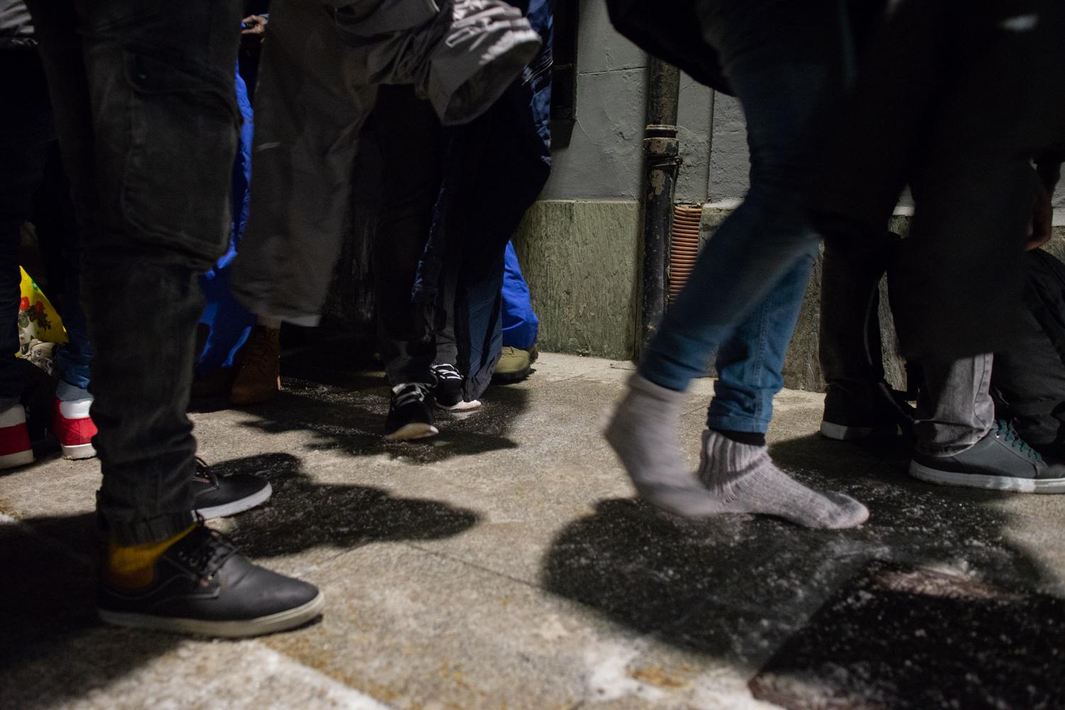 The Way of the Mountain - Homeless asylum-seekers are trying on winter shoes and...