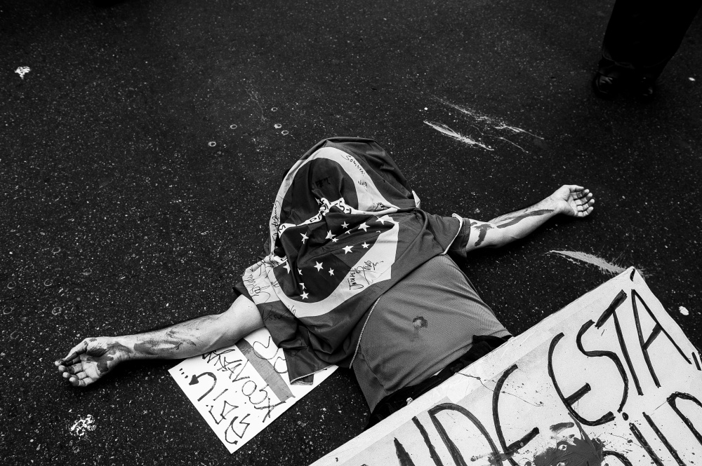 A demonstrator lays down with a...cases and poor public services.