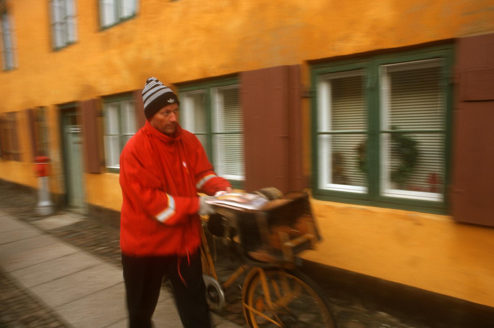 A postman delivers mail in the ...hborhood in Copenhagen, Denmark
