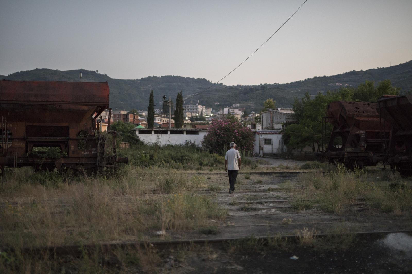 Albania Unemployment - A man takes an evening stroll through an abandoned...