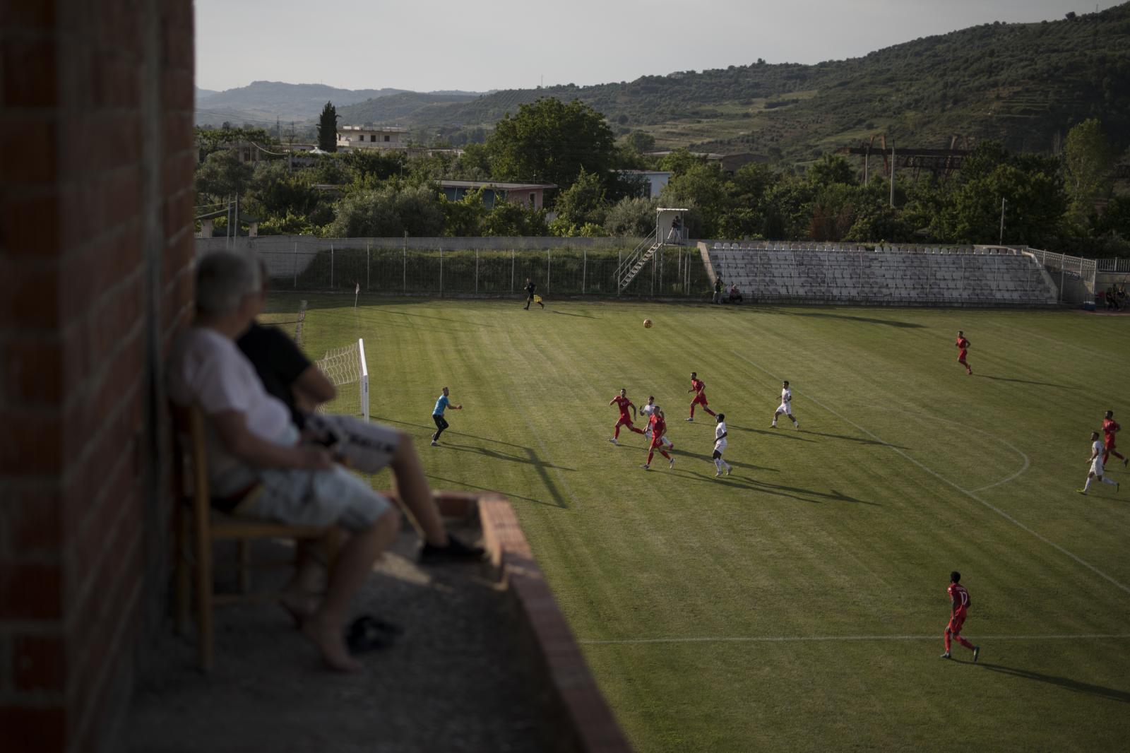 Albania Unemployment - Residents watch a football match played behind closed...