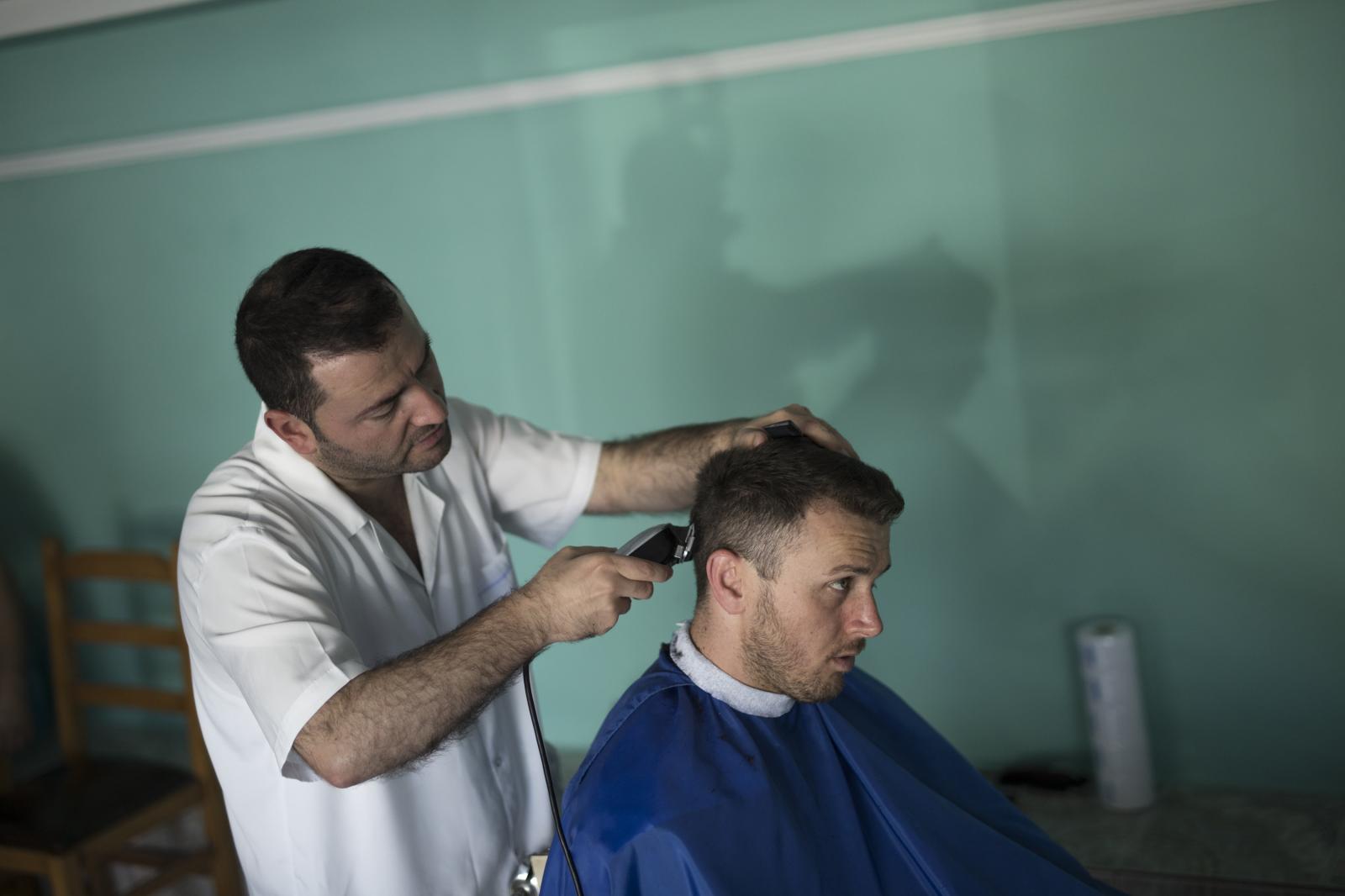 Albania Unemployment - Nick gets a hair cut at a barber shop in the town of...