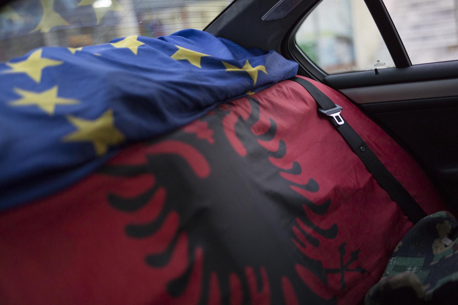 Albania Unemployment - An EU flag and an Albanian flag cover the back seats of a...