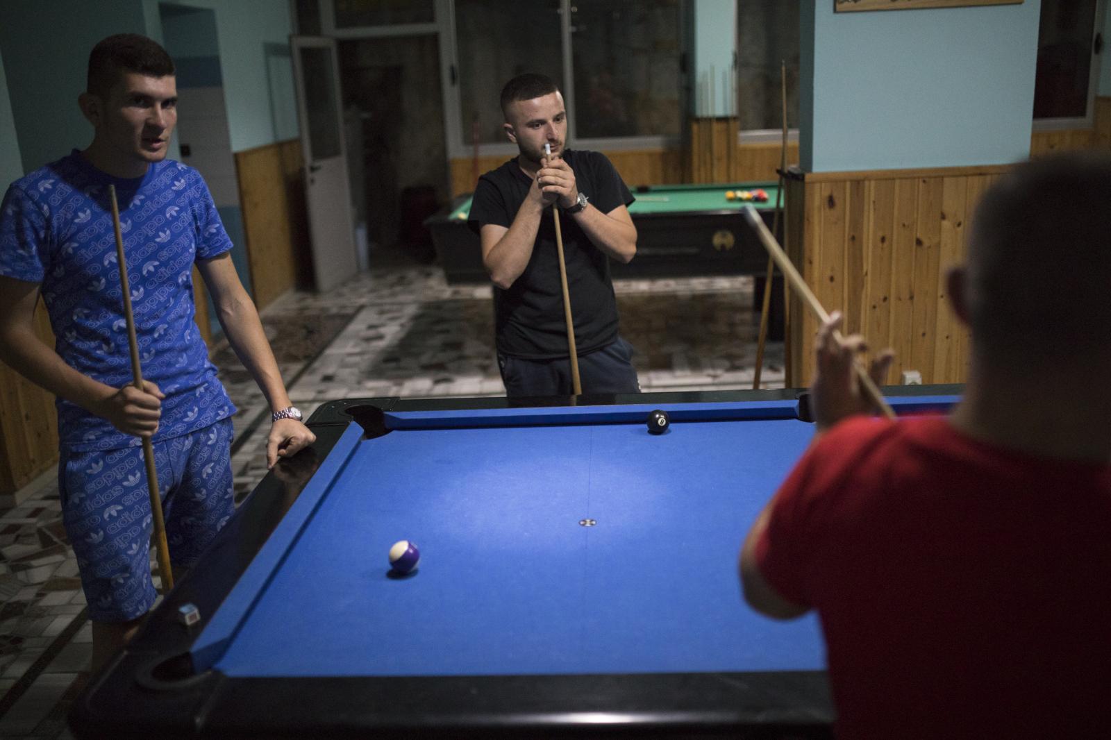 Albania Unemployment - Friends play pool at a leisure hall in the town of...