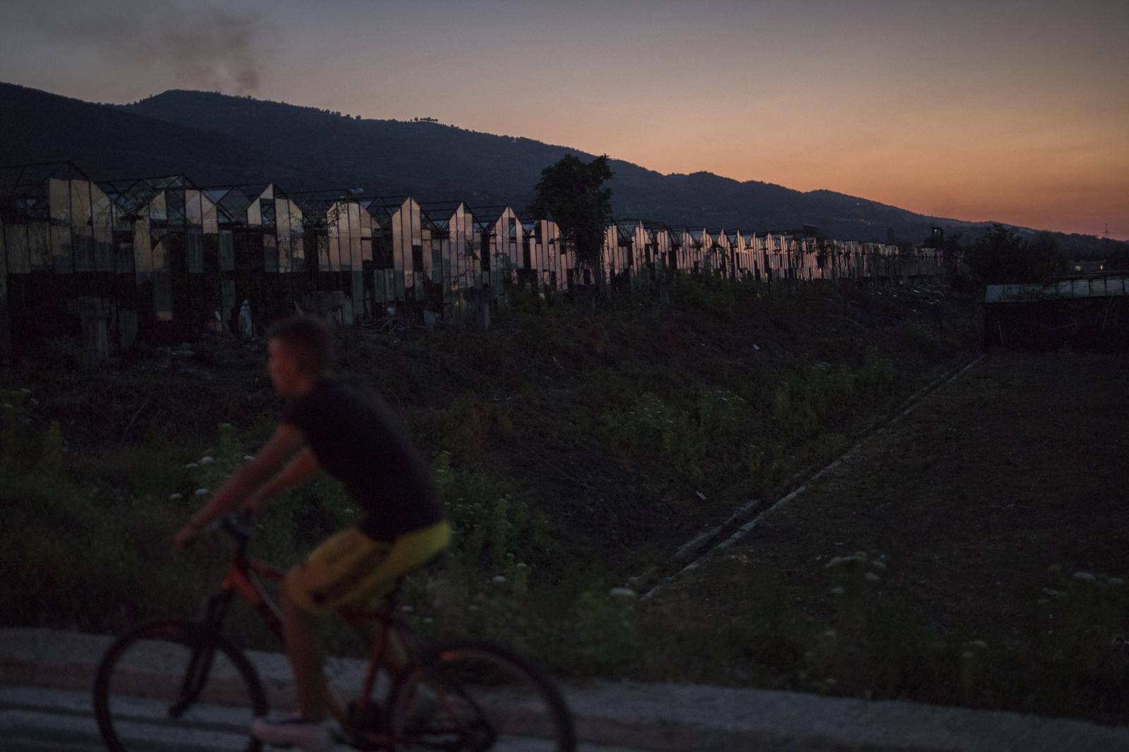 Albania Unemployment - A boy rides a bicycle at sunset in the rural town of...