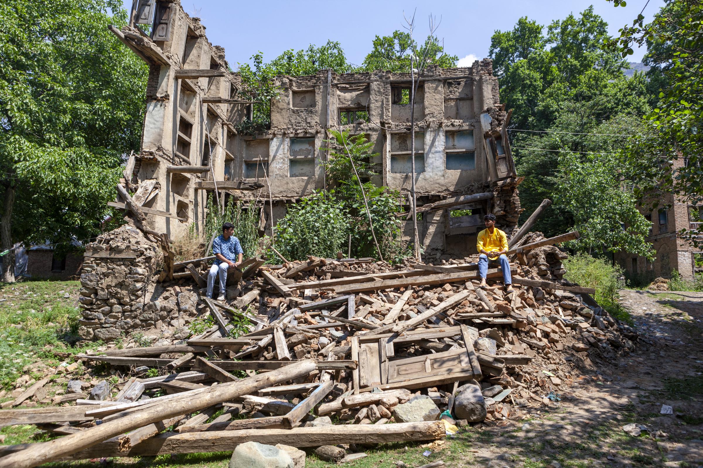 Selective $ympathy  -  Two Kashmiri Pandit brothers sit amid the ruins of a...