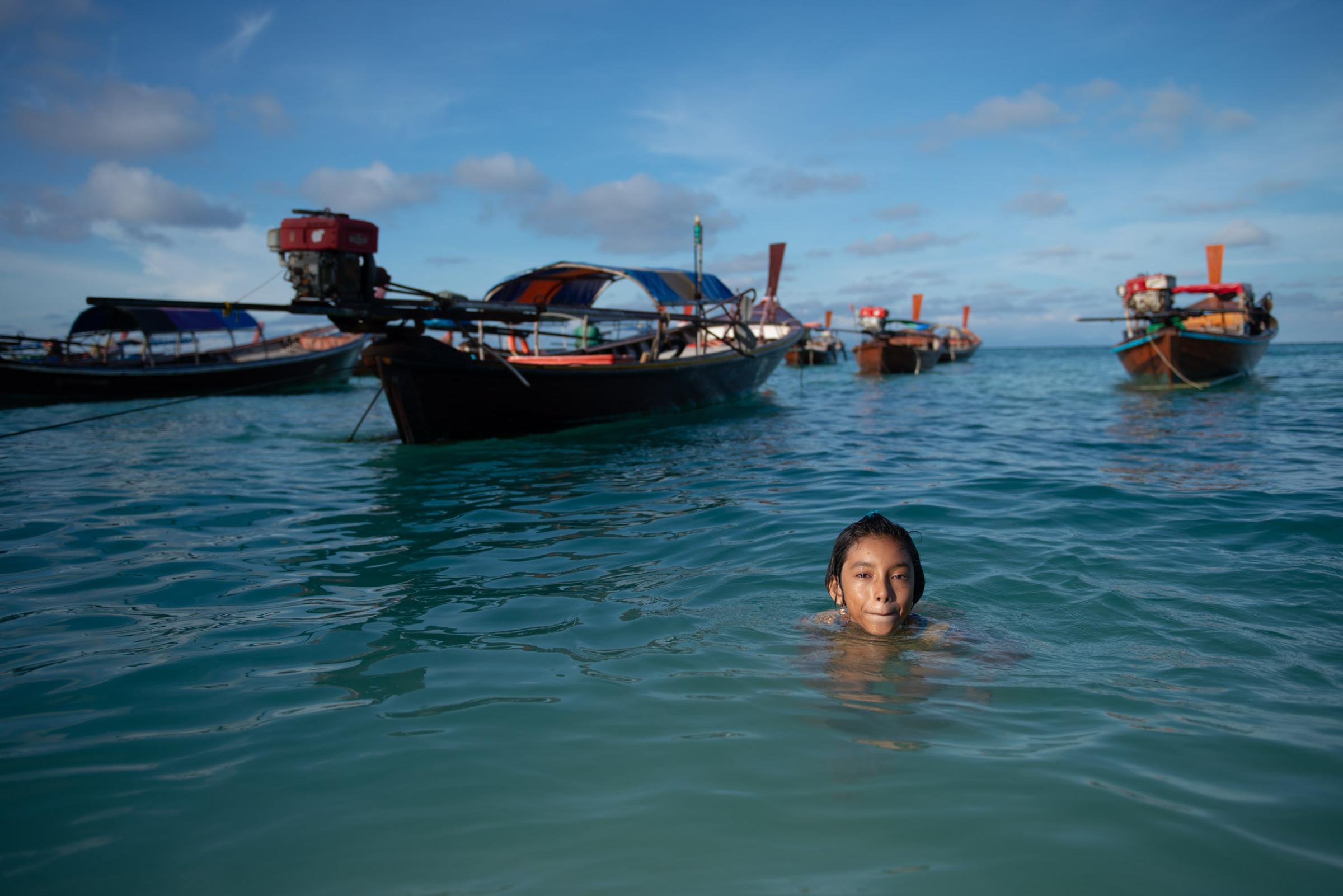 Lipe Island - A young woman swims and raises her head above the surface...