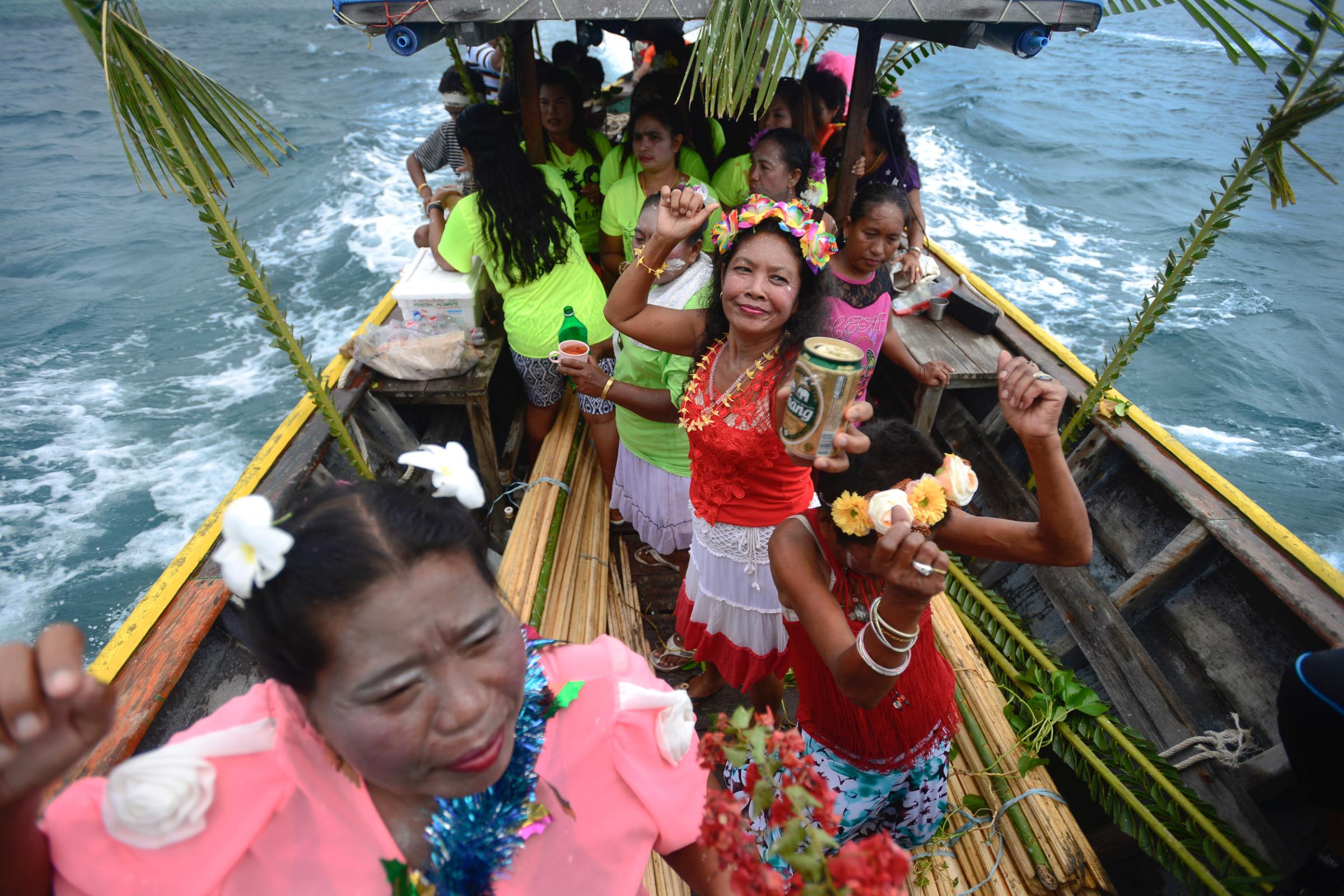 Lipe Island - Sea gypsies celebrate on a boat carrying the Salacca tree...