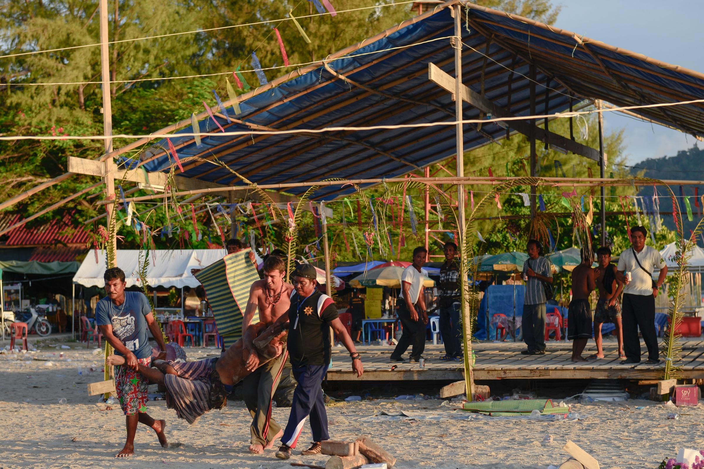 Lipe Island - In the morning, the sea gypsies and a tourist help carry...