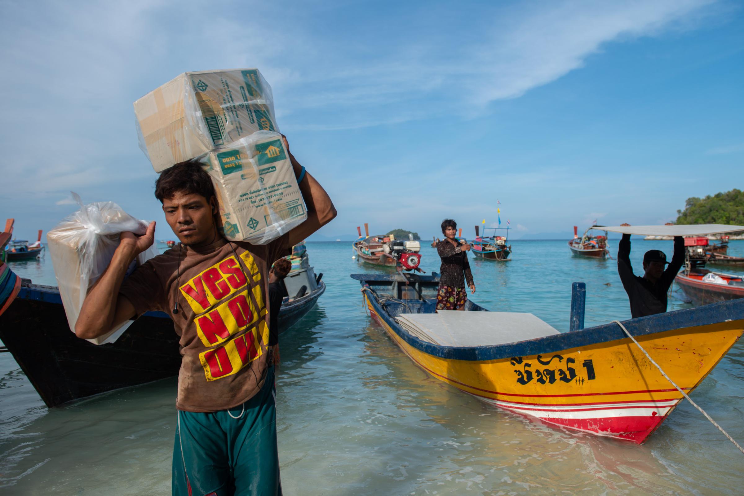 Lipe Island - Workers and local gypsies carry food supplies and...