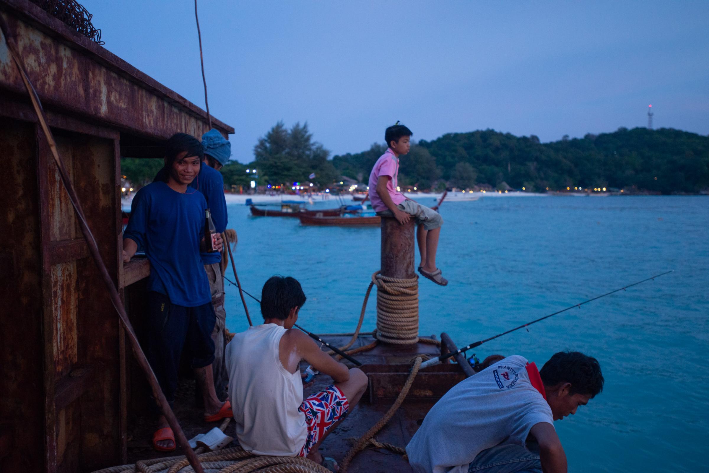 Lipe Island - Burmese construction workers fish at the end of the boat...