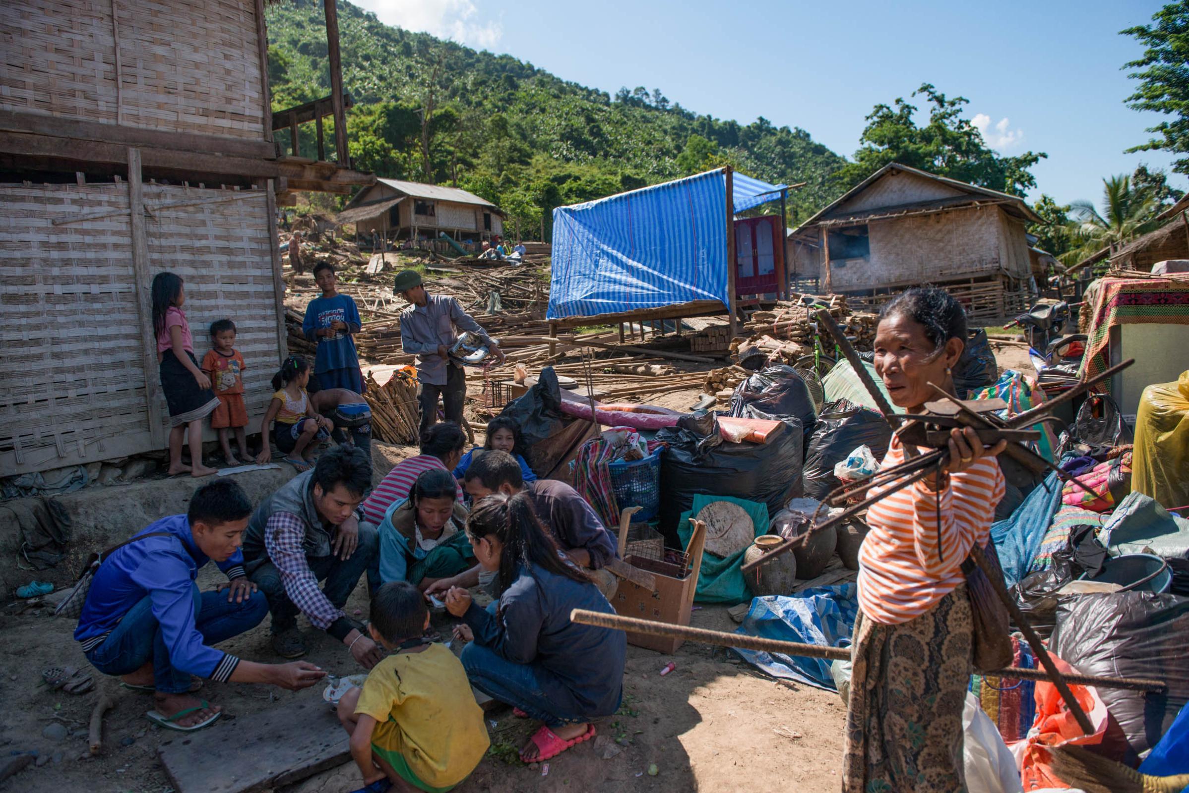 Damming The Mekong River - Villagers gather on the ground to have a meal after their...
