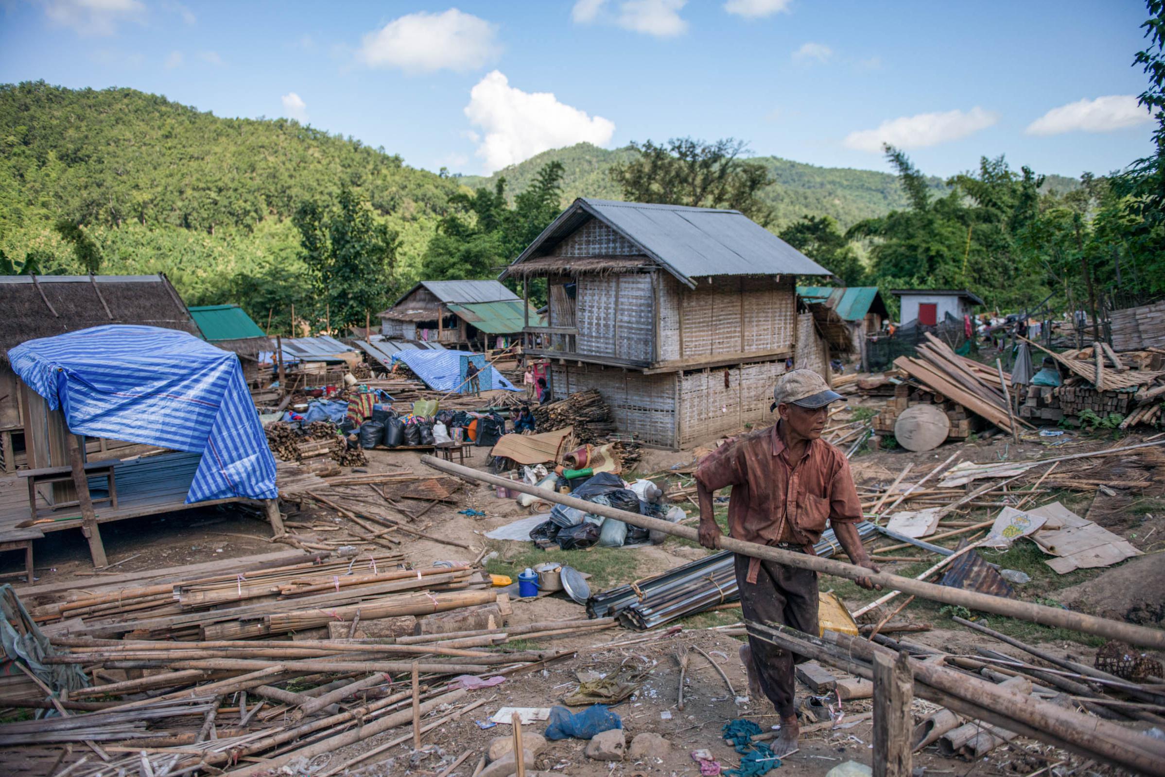 Damming The Mekong River - A villager separates wood, the main building material of...