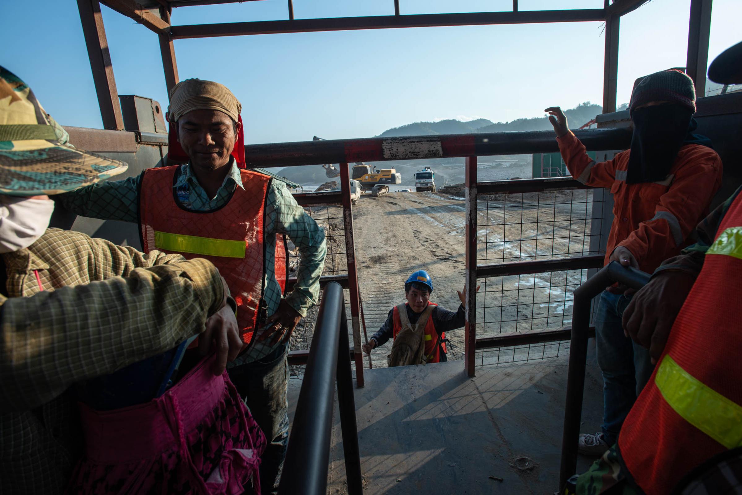 Damming The Mekong River - Construction workers leave the dam construction site on a...