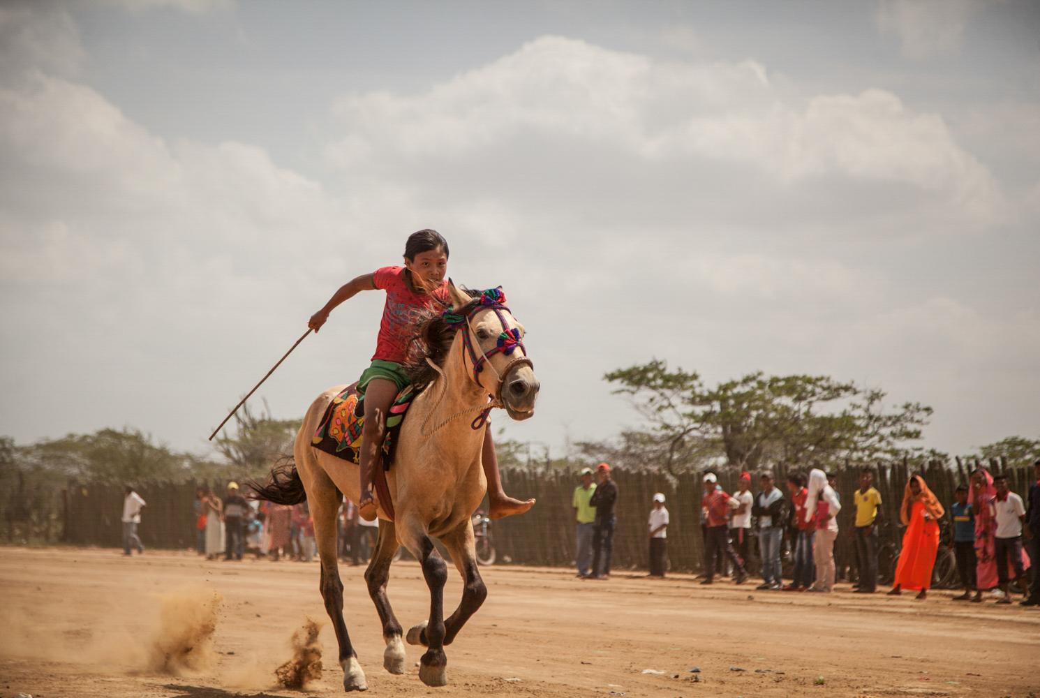 Colombian Indigenous Preserve Identity Across Spiritual Practices - URIBIA, LA GUAJIRA-COLOMBIA JULY 18: Wayuu young boy in the race horse competition in the middle...