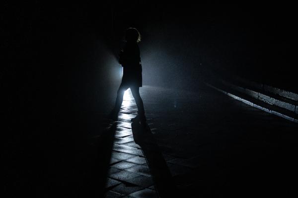 Image from Ukraine Goes Dark - Person walking at dark street without street lights in...