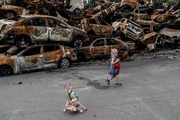 Image from Russian-Ukrainian War - The girl exploring the cemetery of burned civilian cars...