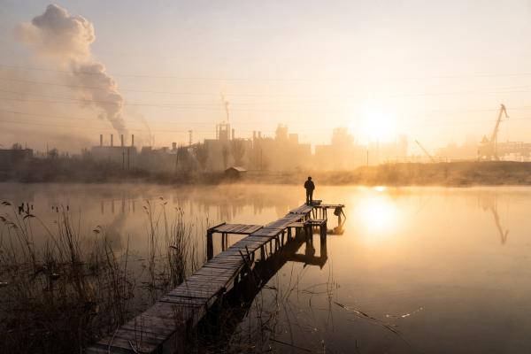 Image from The New Symphony of Donbas - A man is fishing near the Azovstal plant in the Kalmius...