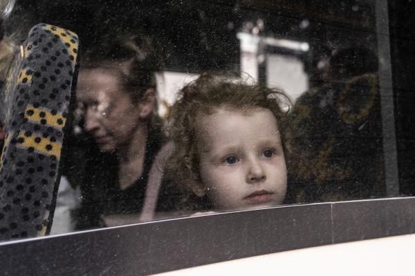 Image from The New Symphony of Donbas - A refugee kid looks through the bus window as the other...