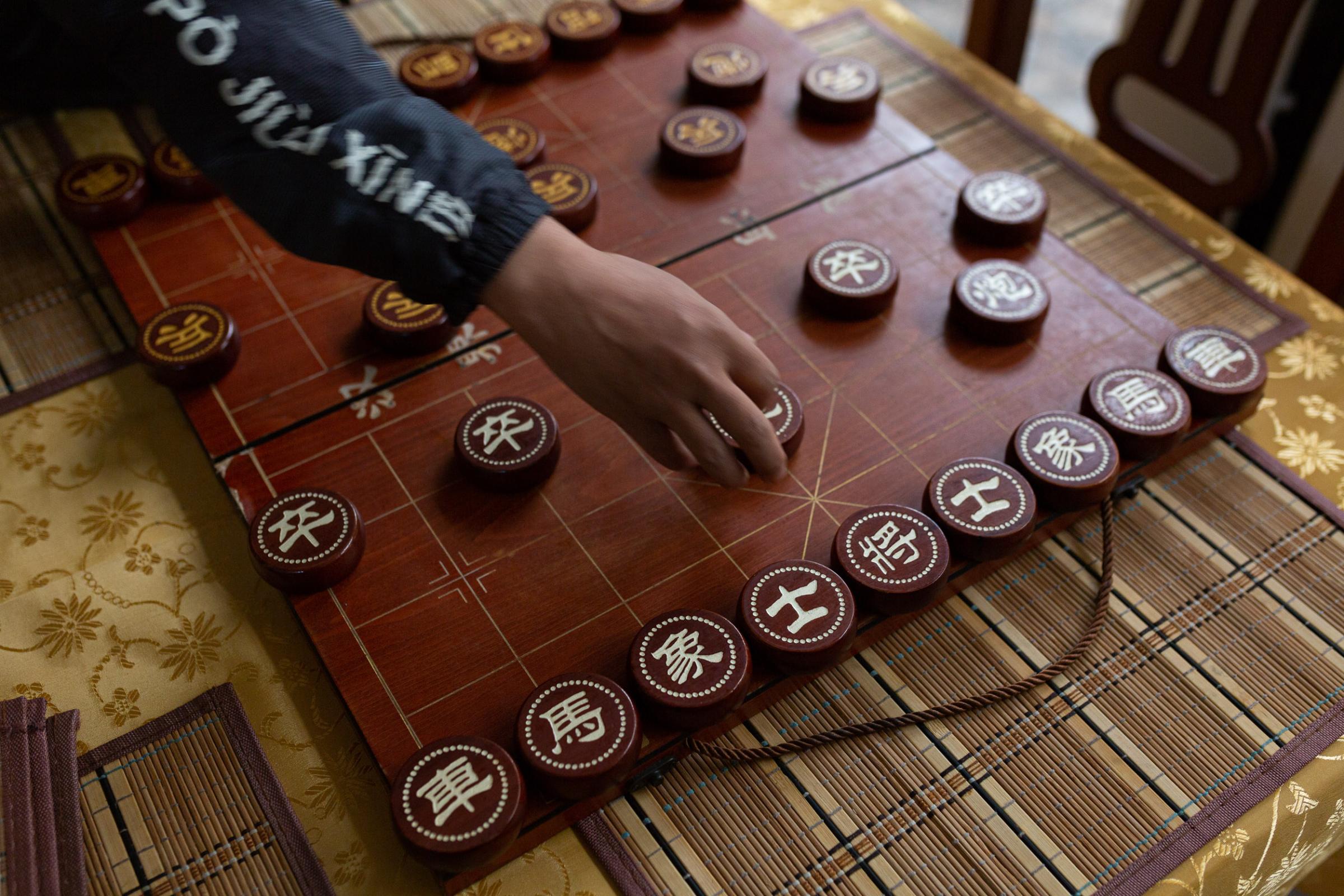 Return to China? Xing would rather die in the jungle - A Chinese board game in the dining room of the hotel...